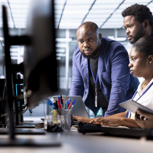 Team of data center office technicians using programming languages to construct algorithms and build applications. Server hub IT staff members debugging and optimizing code